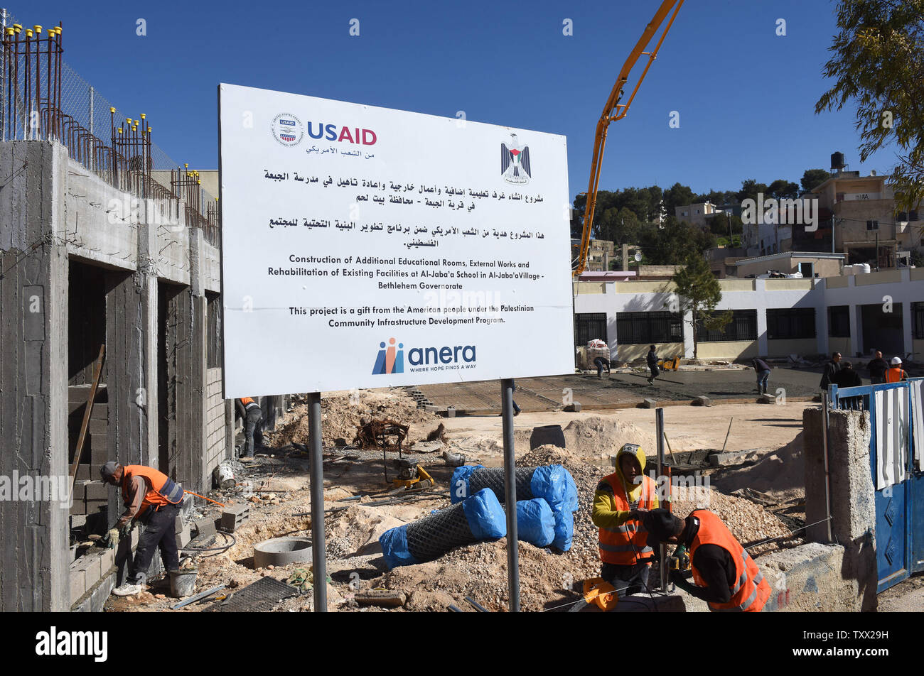 Palestinian construction workers renovate and build an extension to the girl's school in Al-Jabba, near Bethlehem, West Bank, which is funded by USAid, United States Agency for International Development, January 23, 2019. The $1.4 million dollar project will be terminated at the end of January because U.S. President Donald Trump's administration will stop funding Palestinian projects and also because Palestinian Prime Minister Rami Hamdallah has stated that the Palestinian Authority will cease accepting funding from America. The school will be unusable for the 250 girl students who attend the Stock Photo
