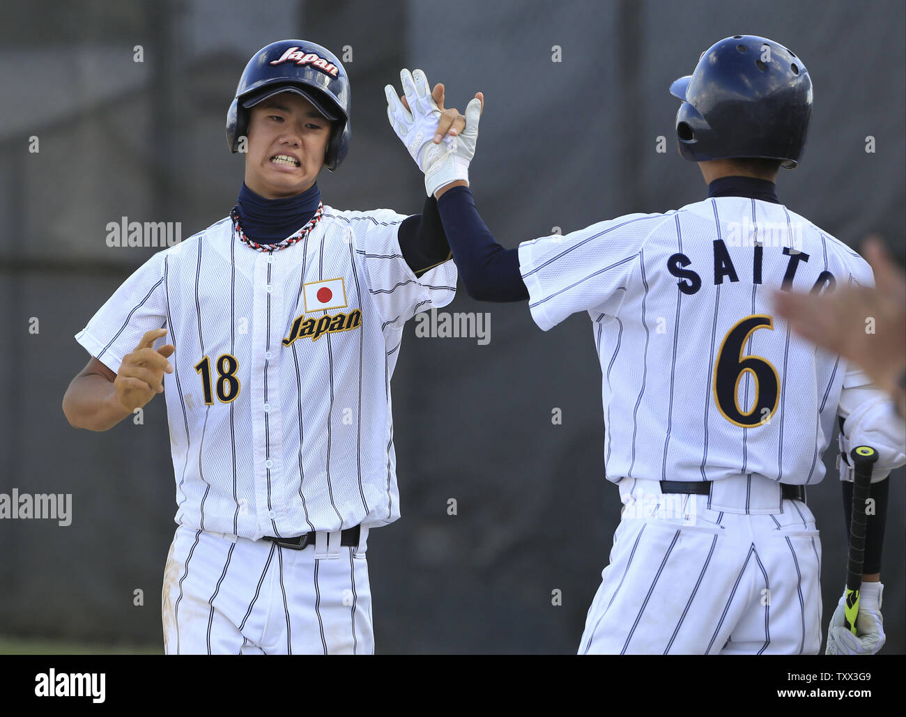 (L-R) Japan's Riku Kawahara high fives Reiji Saito after scoring on a wild pitch during the second inning of the first game of the McHenry County Youth Sports Association's 23rd annual 15-Year-Old International Championship on August 1, 2015 in Crystal Lake, Illinois.  Japan lost to Los Lomas Potros 6-4 in their first game but defeated them 3-2 in their second game to win the championship.. Photo by John Konstantaras/UPI Stock Photo