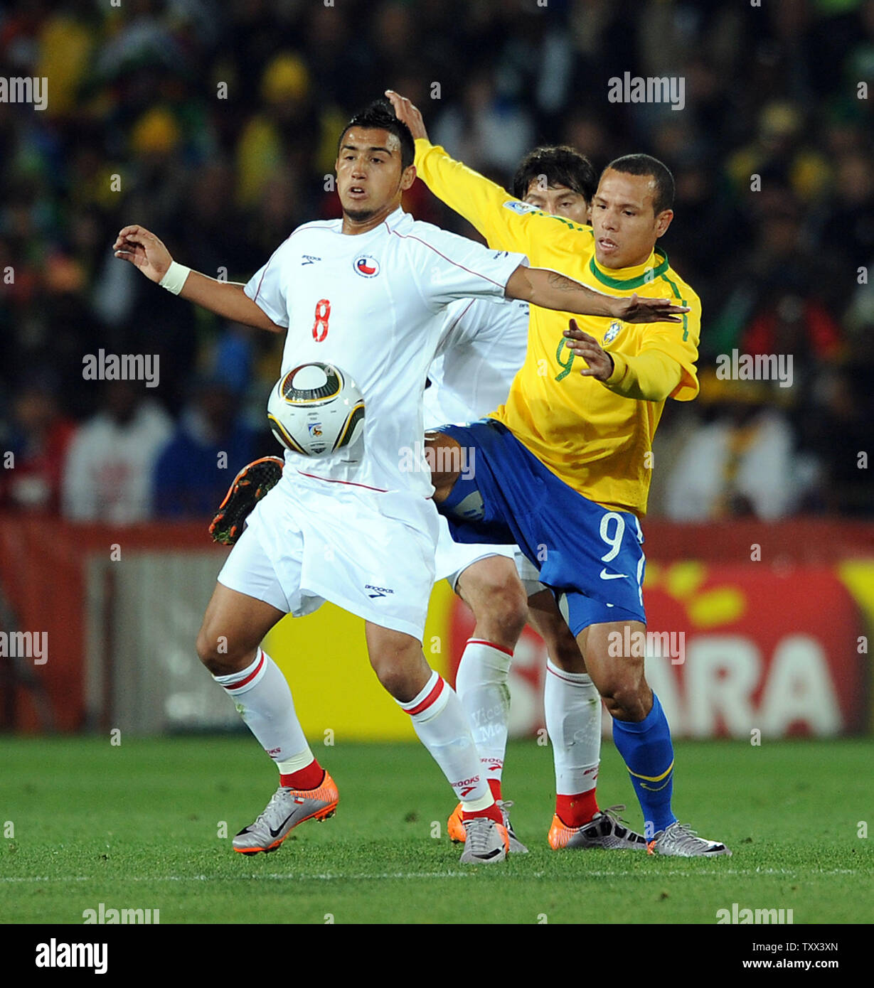 Luis Fabiano of Brazil and Arturo Vidal of Chile during the FIFA World Cup Round of 16 match at Ellis Park in Johannesburg, South Africa on June 28, 2010. UPI/Chris Brunskill Stock Photo