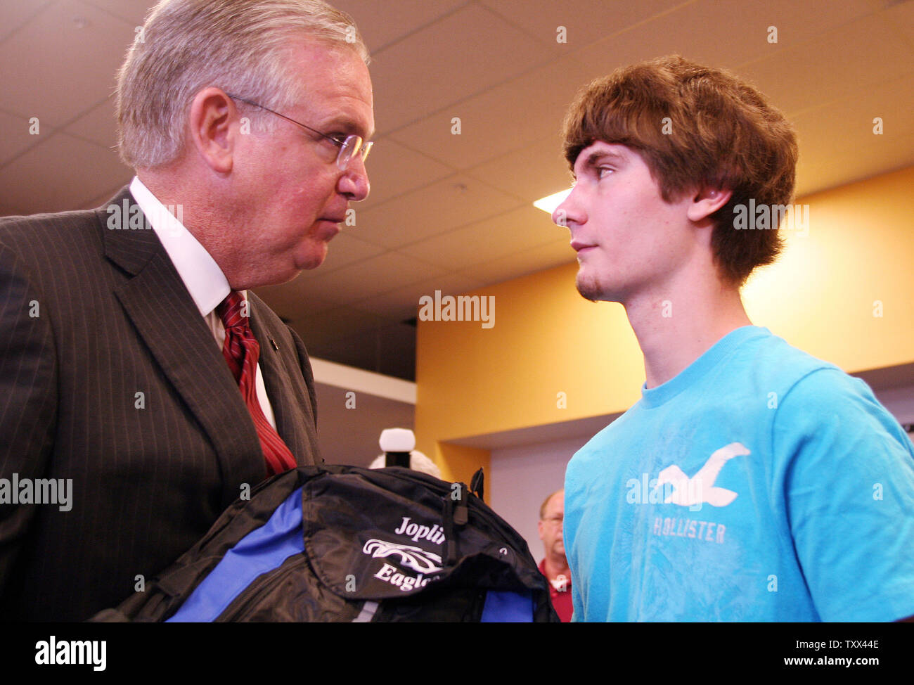 Mo. Gov. Jay Nixon hands the first computer to senior Quinton Anderson on opening day of school in Joplin, Missouri on August 17, 2011. Anderson, who was critically injured in the May 22 tornado that killed 160 people, lost both parents in the storm. Free laptops were distributed to students at Joplin High School as part of a $1 million gift from the United Arab Emirates.  UPI/Tom Uhlenbrock Stock Photo