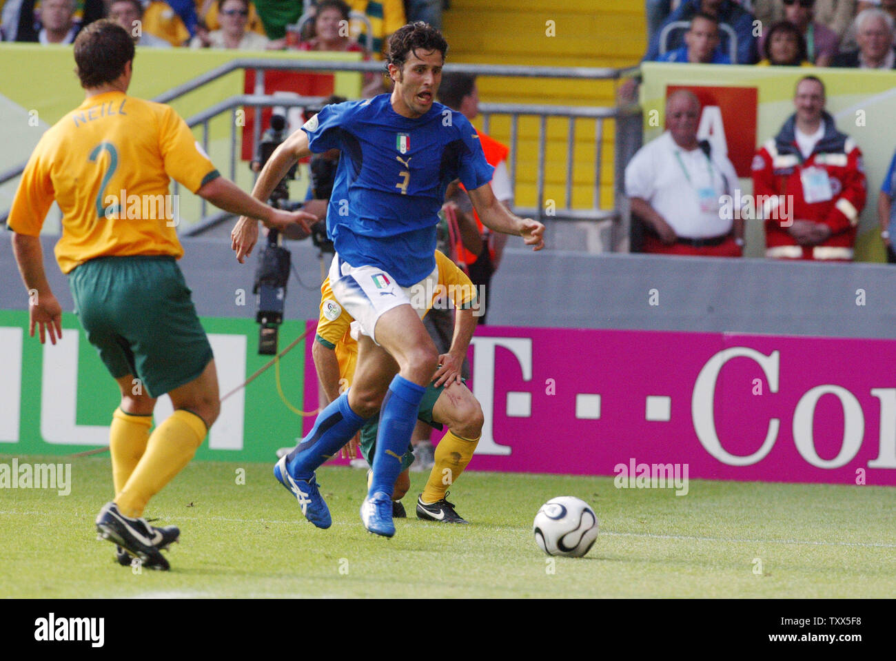 In play leading up to a game deciding penalty,  Italy's Fabio Grosso (3) dribbles toward the goal as Australia's player Luca Neill (2) moves in from left  in World Cup soccer in Kaiserslautern, Germany on June 26, 2006. Italy eliminated Australia from World Cup competition 1-0.  (UPI Photo/Arthur Thill) Stock Photo