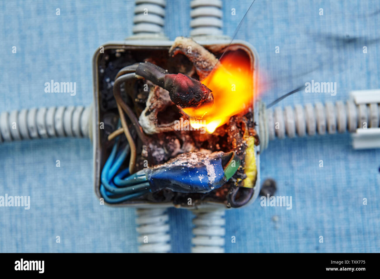 Damaged electrical junction box became cause of electrical short circuit and caused the electric wiring to ignition of fire. Stock Photo