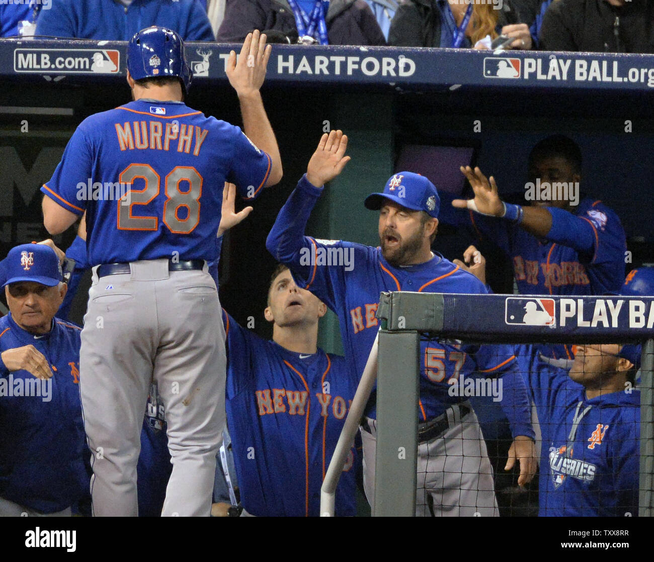 New York Mets second baseman Daniel Murphy receives high fives in dugout after scoring in the fourth inning on RBI single by teammate Travis d'Arnaud against the Kansas City Royals in game 1 of the World Series at Kauffman Stadium in Kansas City, Missouri on October 27, 2015. The Royals will play the New York Mets in the 2015 World.  Photo by Kevin Dietsch/UPI Stock Photo