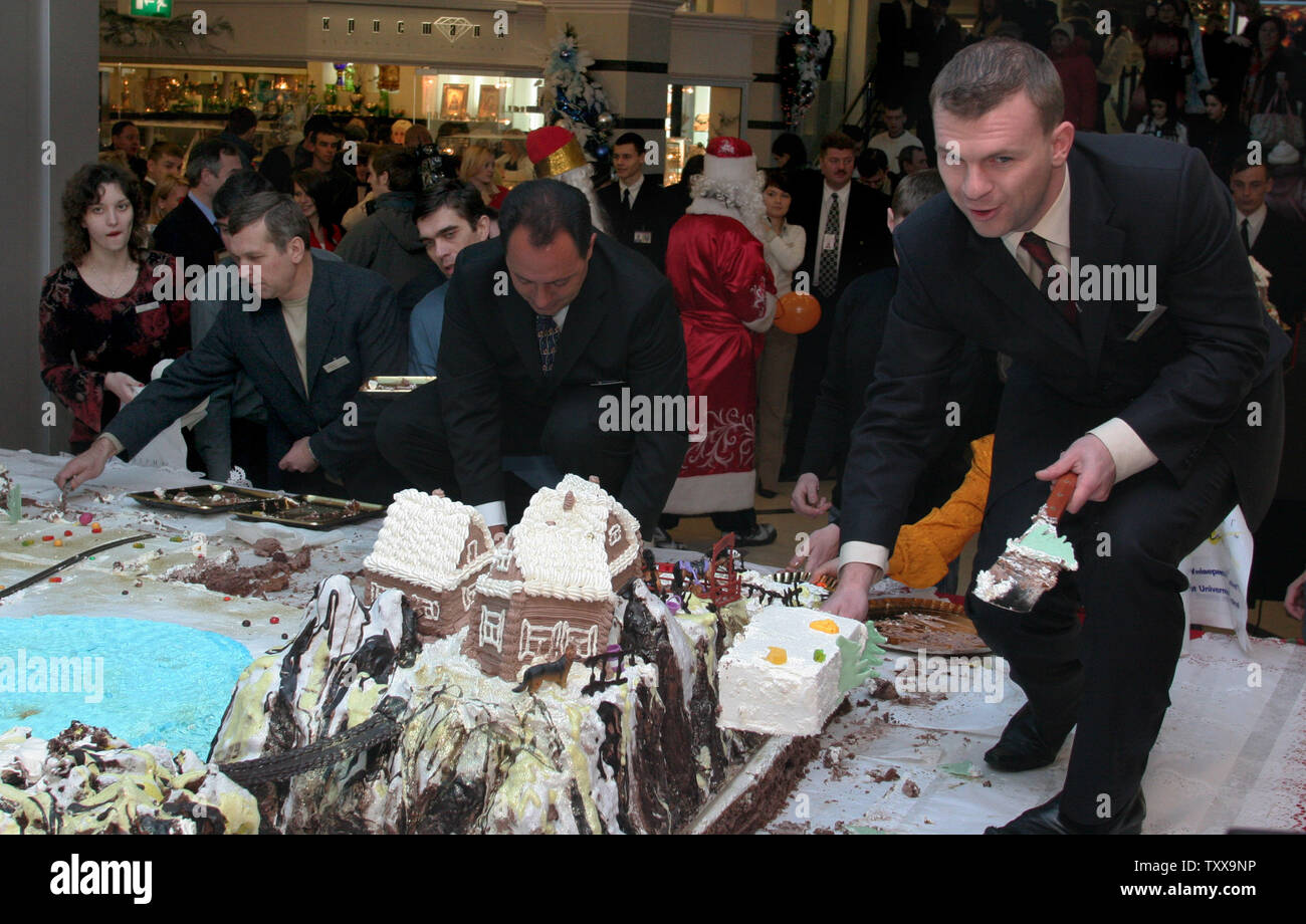 A man serves pieces of a giant New Year's cake at a shopping mall in