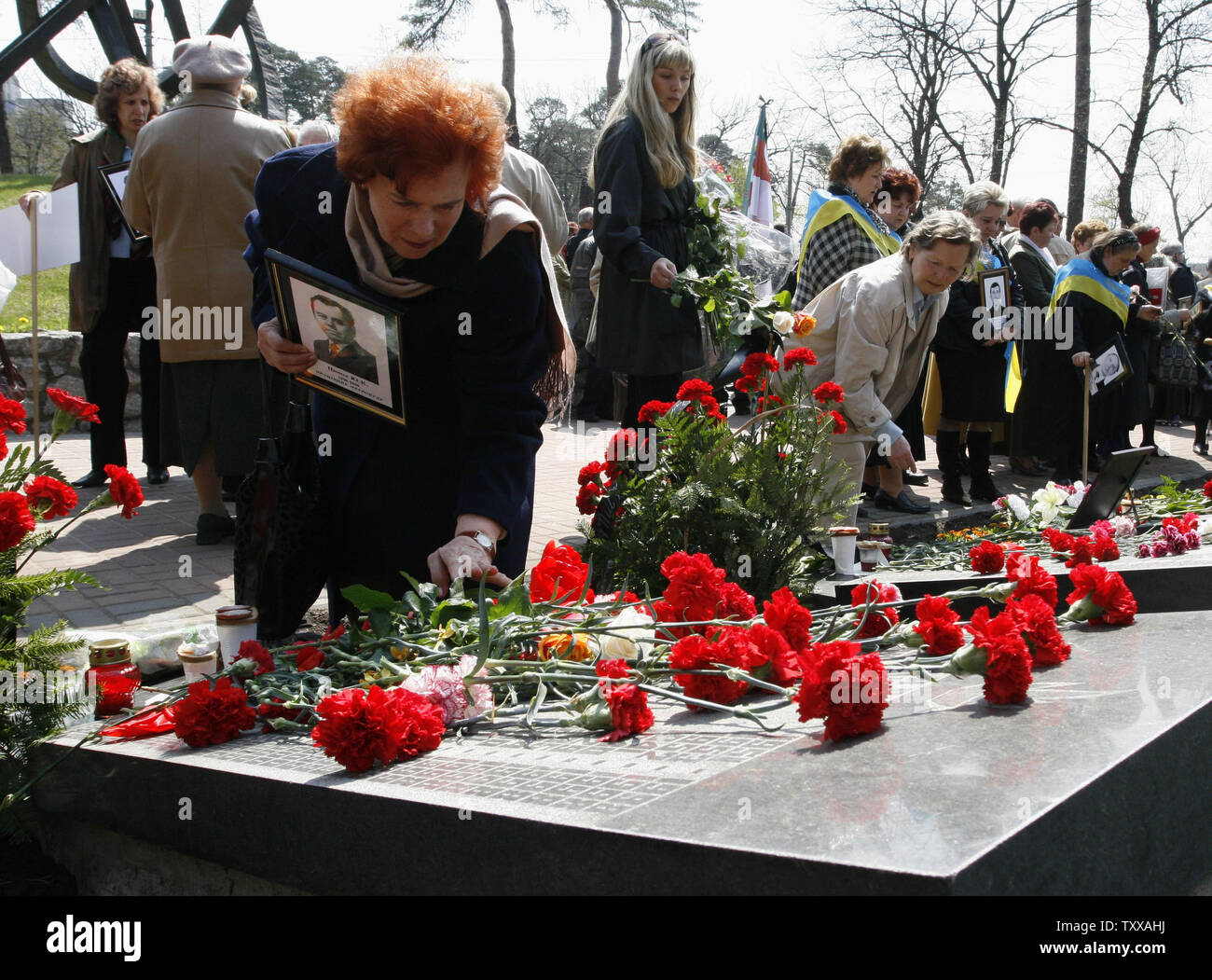 People place flowers at the memorial to Chernobyl victims in Kiev on April 26, 2007. Ukraine marks the 21st anniversary of the world's worst civil nuclear tragedy when Chernobyl's reactor No.4 exploded sending radioactive clouds in the air, poisoning vast areas in Ukraine, Belarus and Russia, and contaminating much of Europe. (UPI Photo/Sergey Starostenko) Stock Photo