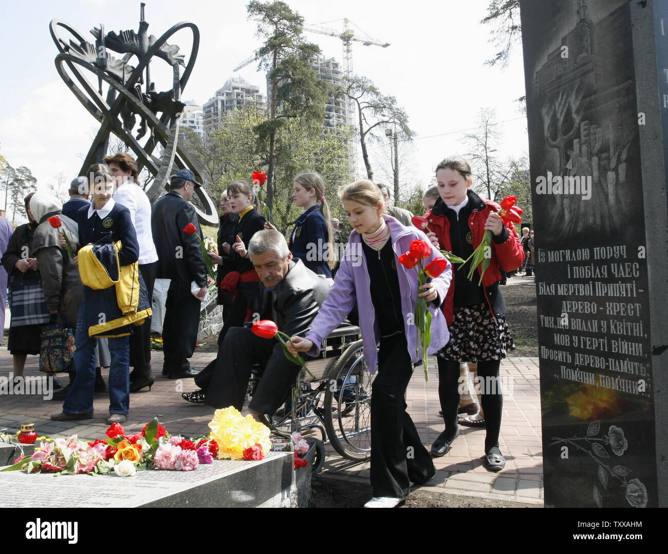 People place flowers at the memorial to Chernobyl victims in Kiev on April 26, 2007. Ukraine marks the 21st anniversary of the world's worst civil nuclear tragedy when Chernobyl's reactor No.4 exploded sending radioactive clouds in the air, poisoning vast areas in Ukraine, Belarus and Russia, and contaminating much of Europe. (UPI Photo/Sergey Starostenko) Stock Photo