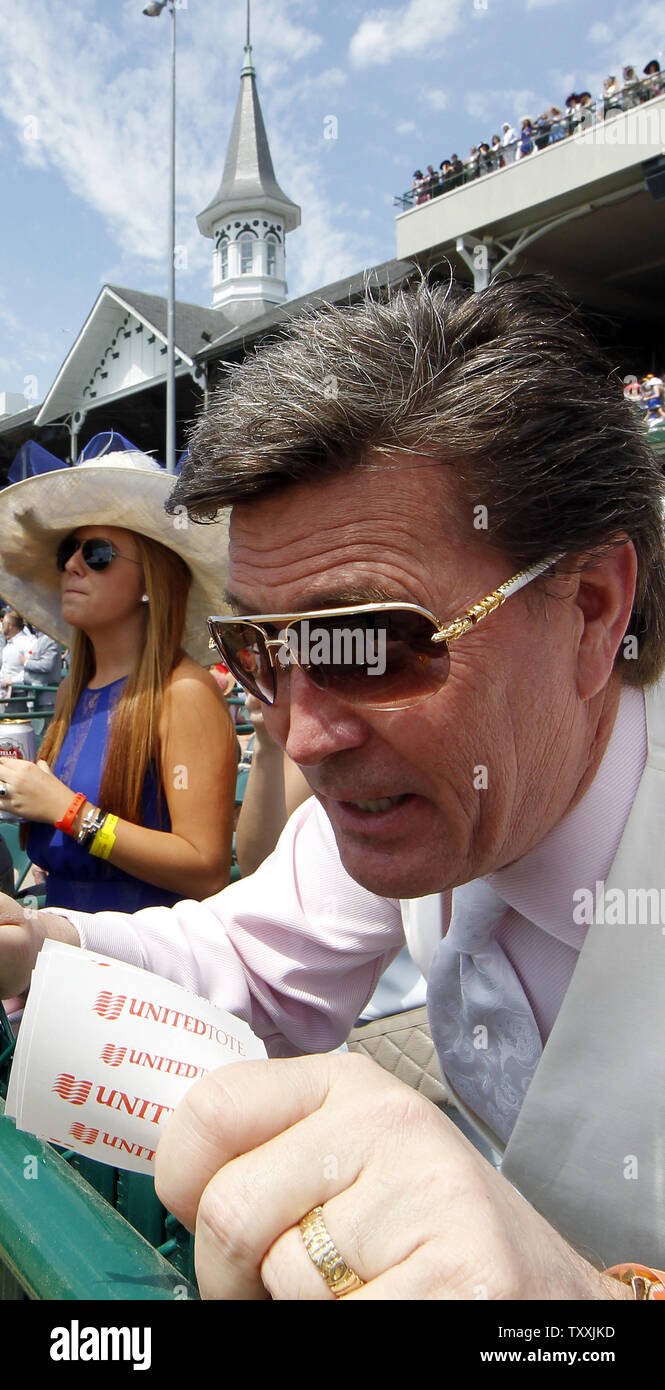 A race fan checks his betting slips as horses running the fifth race head toward the finish line at Churchill Downs Derby Day on May 2, 2015 in Louisville, Kentucky. Eighteen horses will compete in the 141st running of the Kentucky Derby at Churchill Downs Saturday, May 2. Photo by Frank Polich/UPI Stock Photo