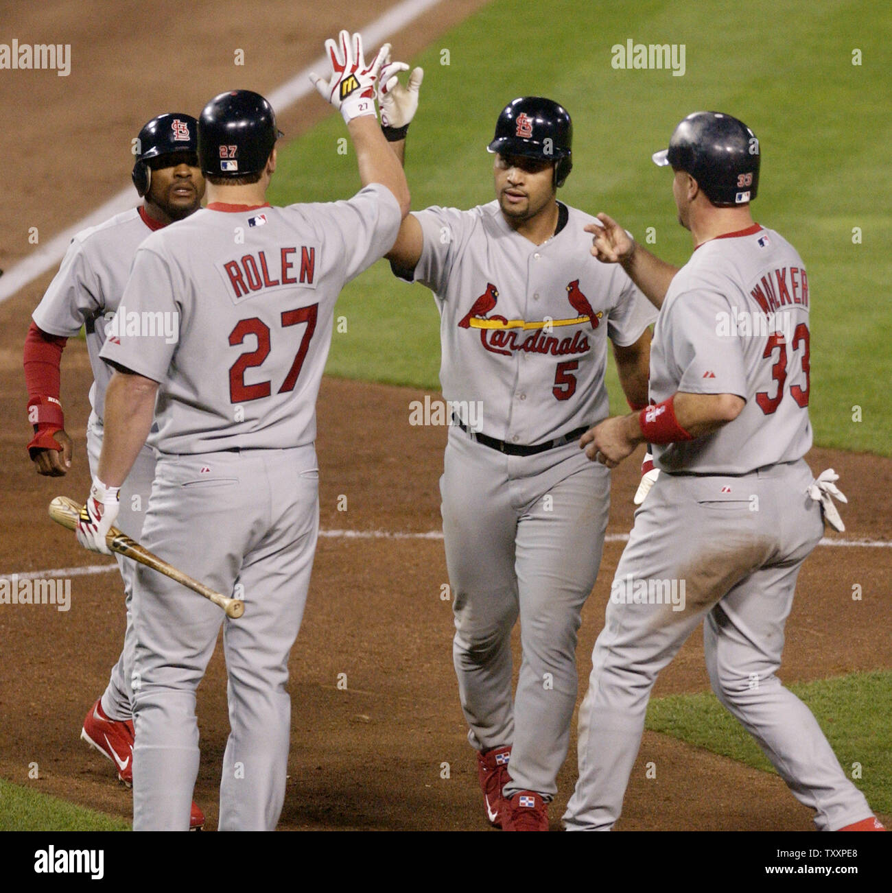 St. Louis Cardinals' Albert Pujols (5) is welcomed home by teammates Scott  Rolen (27) and Larry Walker (33) after belting a three run homer in the  fourth inning against the Dodgers in