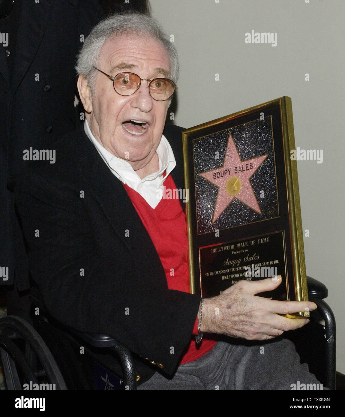 Comedian Soupy Sales holds a replica plaque of his just unveiled star on the Hollywood Walk of Fame, following a brief, rain-soaked ceremony in Los Angeles, California January 7, 2005. Sales, who will celebrate his 79th birthday Saturday, Jan. 8 was famous for tossing cream-pies in the face's of celebrities during his 1950's variety show. (UPI Photo/Jim Ruymen) Stock Photo