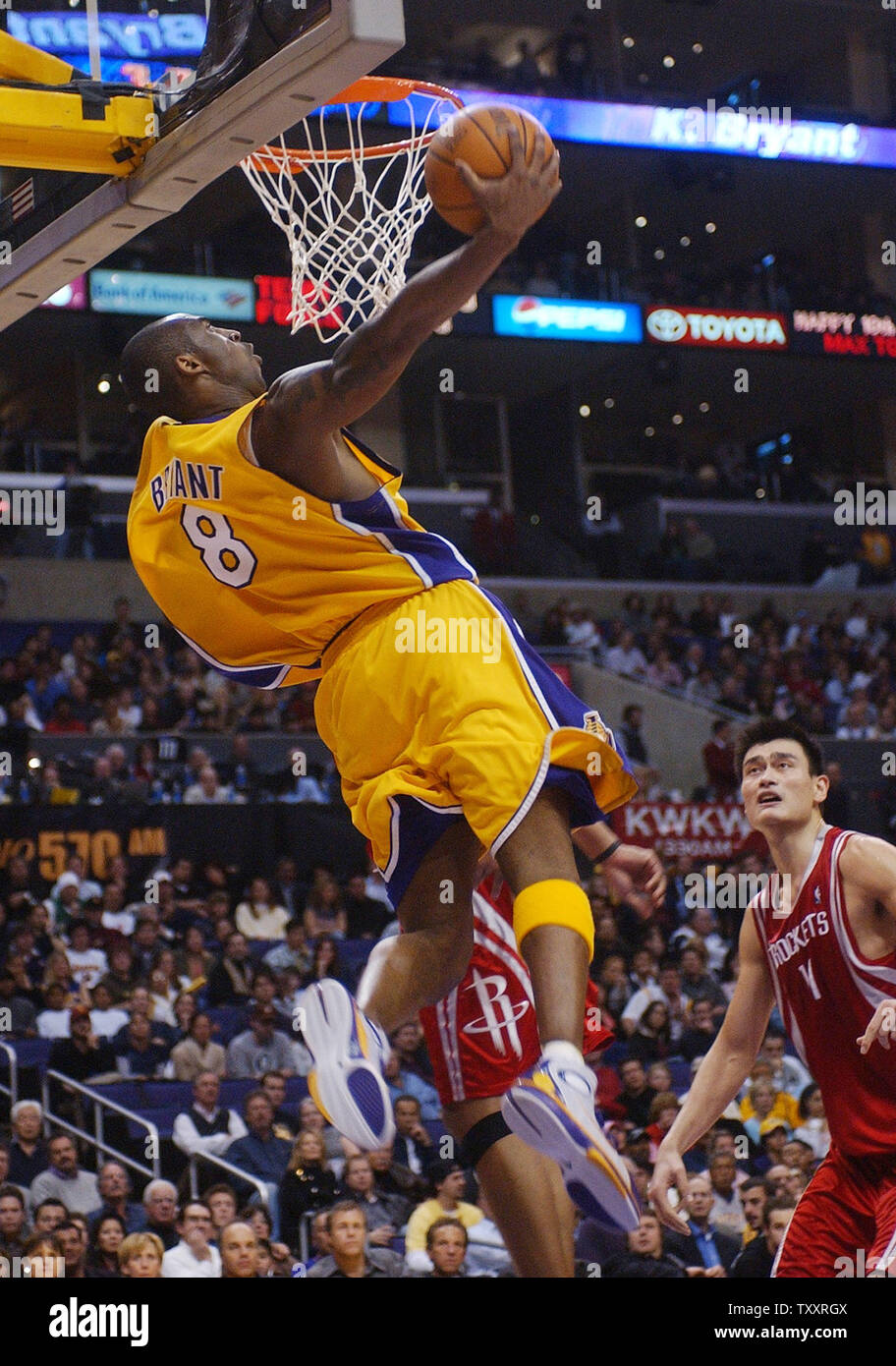 Los Angeles Lakers guard Kobe Bryant scores two points on a reverse jam during third quarter action as Houston Rocket center Yao Ming of China looks on in their NBA game at Staples Center in Los Angeles January 7, 2005. The Lakers defeated The Rockets 111-104.   (UPI Photo/Jim Ruymen) Stock Photo