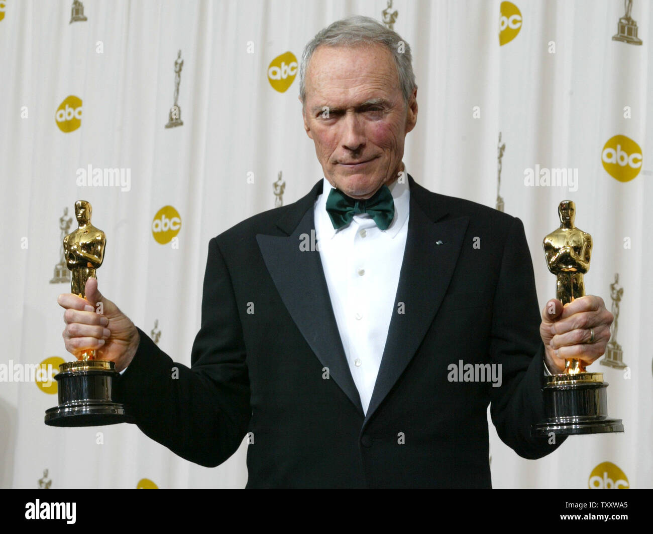 Clint Eastwood shows off the Oscars he won for Best Director and Best