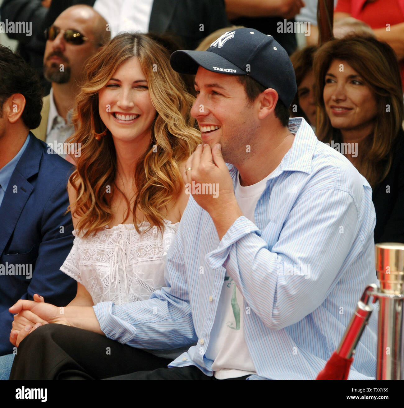 Actor Adam Sandler (R) and his wife Jackie Titone react to remarks by his  mother Judy Sandler during a hand and footprint ceremony honoring Adam  Sandler in the forecourt of Grauman's Chinese