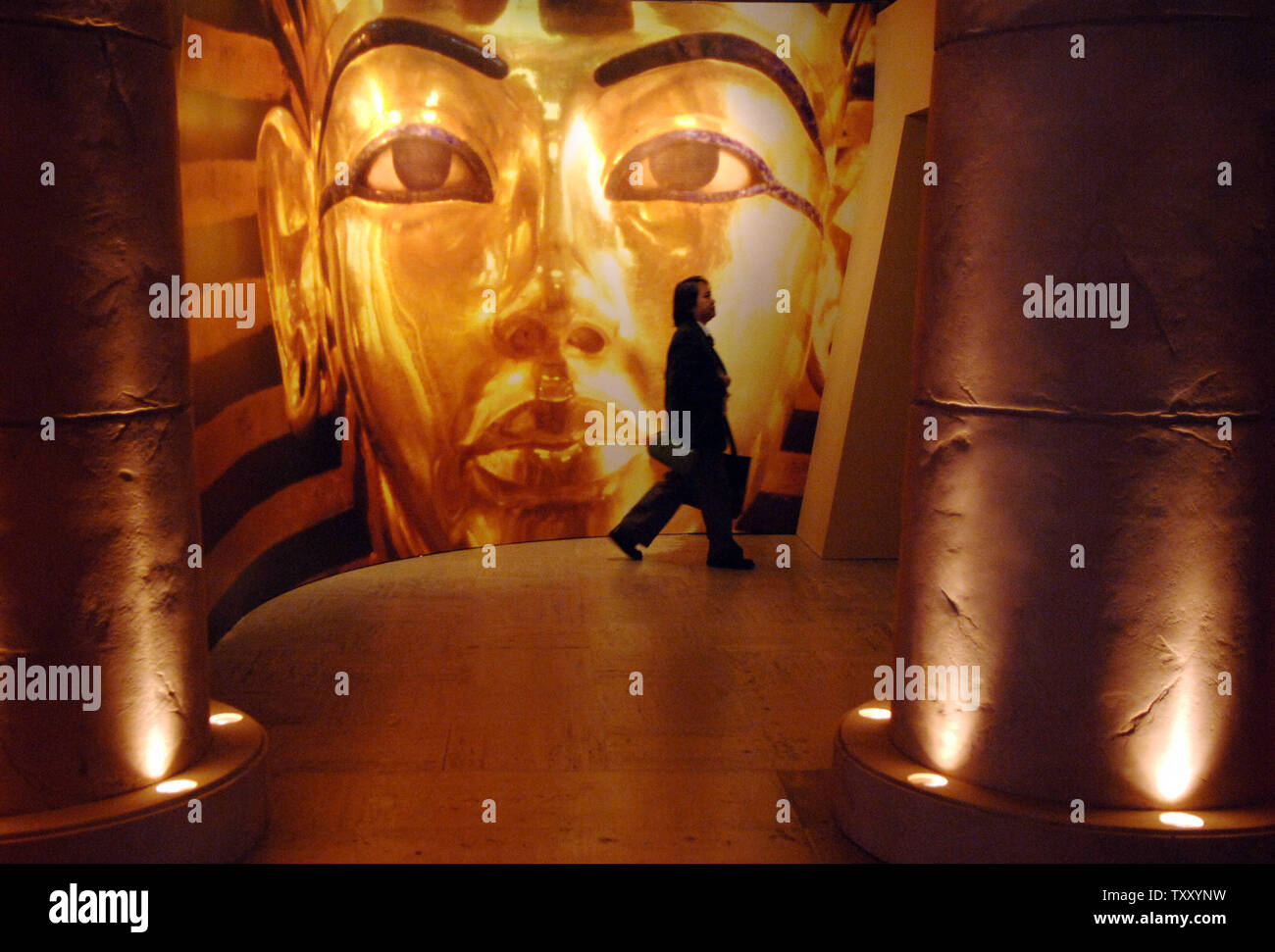 A security guard walks across a hallway, the beginning of the 'Tutankhamun and the Golden Age of Pharaohs' exhibition, featuring stone columns and a large photograph of King Tut at the Los Angeles County Museum of Art on opening day in Los Angeles June 17, 2005. Artifacts from tombs of the Egyptian boy King Tutankhamun and of several of his relatives are part of a 130-piece exhibition, organized by National Geographic with the cooperation of the Egyptian Supreme Council of Antiquities, which begins a 27-month tour of the U.S. Nearly 300,000 advance tickets have been sold. (UPI Photo/Jim Ruymen Stock Photo