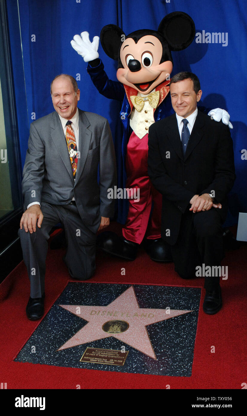 Michael Eisner (L), CEO of the Walt Disney Company and Robert Iger,  CEO-elect and president of The Walt Disney Company kneel with Mickey Mouse  next to a star on the Hollywood Walk