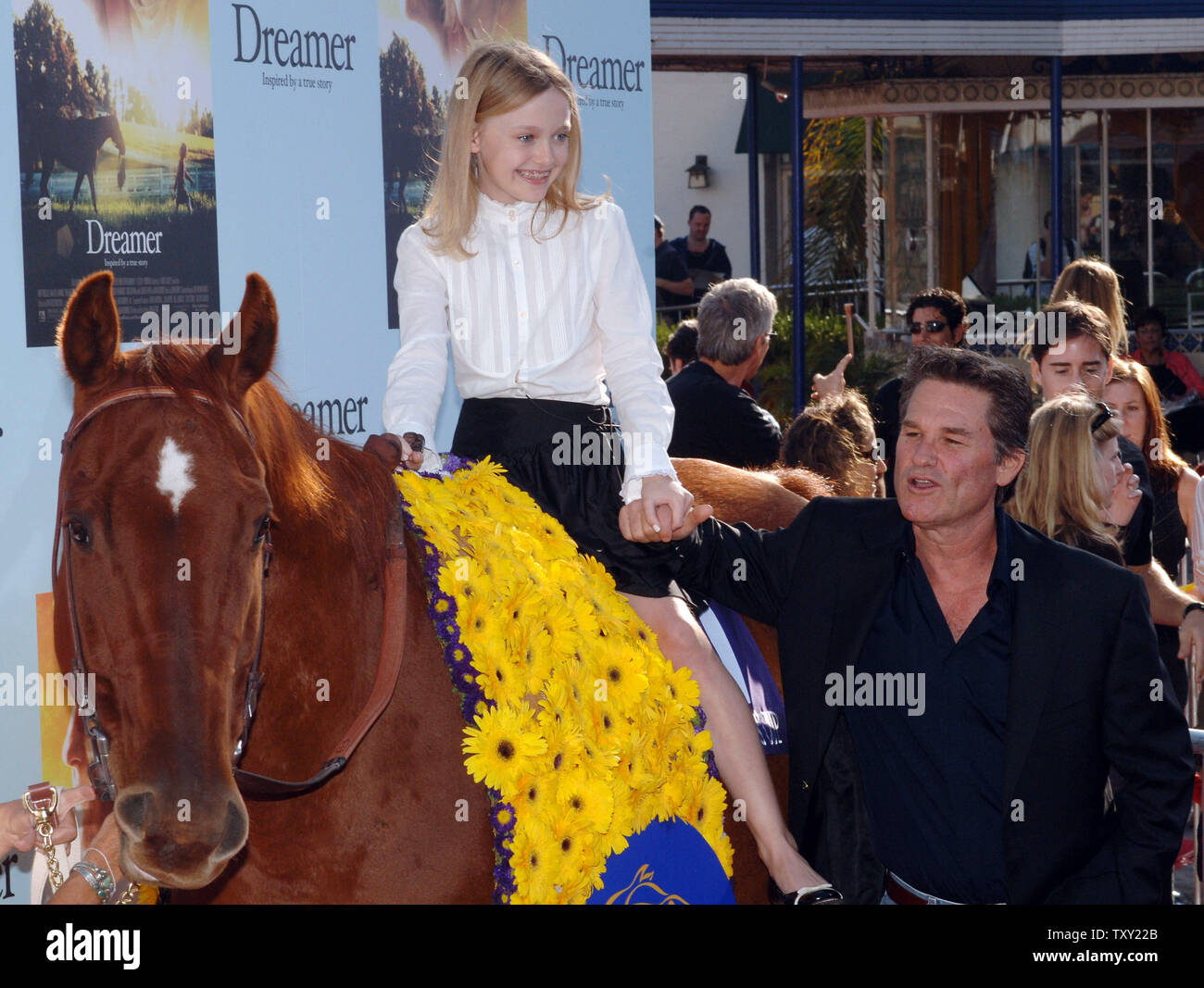 Actors Kurt Russell (R) and Dakota Fanning (atop horse), cast members