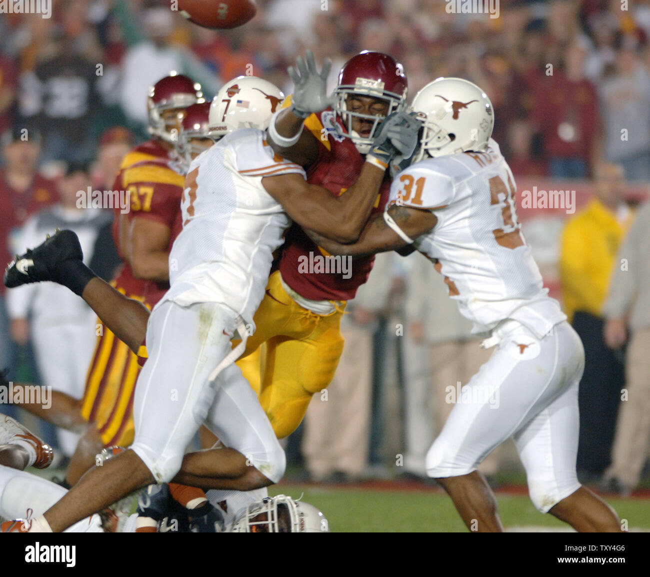 University of Southern California tailback Reggie Bush (#5) attempts to lateral the ball under pressure by University of Texas cornerbacks Michael Huff (#7) and Marcus Myers (#31) during second quarter action of the 92nd Rose Bowl Game in Pasadena, California on  January 4, 2004.  (UPI Photo/Phil McCarten) Stock Photo