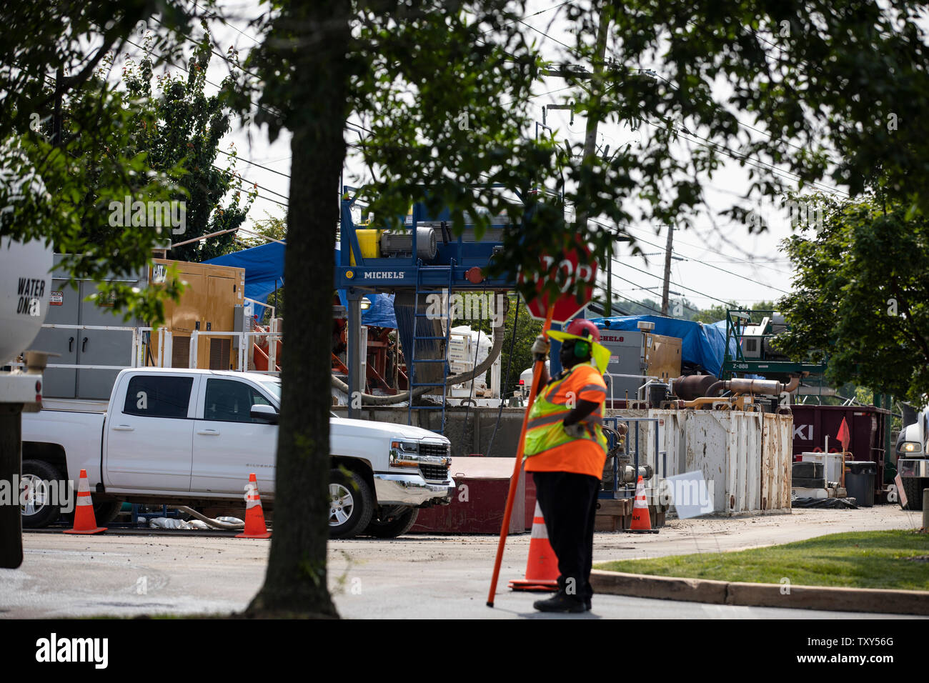 A traffic guard stands near a horizontal boring device for the ETP-Sunoco Mariner East 2 pipeline in West Chester, Pennsylvania on June 5, 2019. Once completed, the 350-mile Mariner East 2 pipeline will carry 275,000 gallons per day of liquid natural gas by-products from the Marcellus Shale and stretch across Pennsylvania ending at Marcus Hook, Delaware where the petroleum products will be exported to other states and overseas. Stock Photo