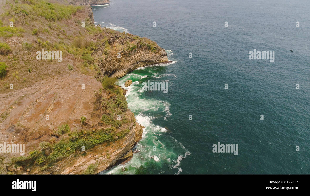 aerial view rocky coastline with cliffs, ocean surf with breaking waves ...