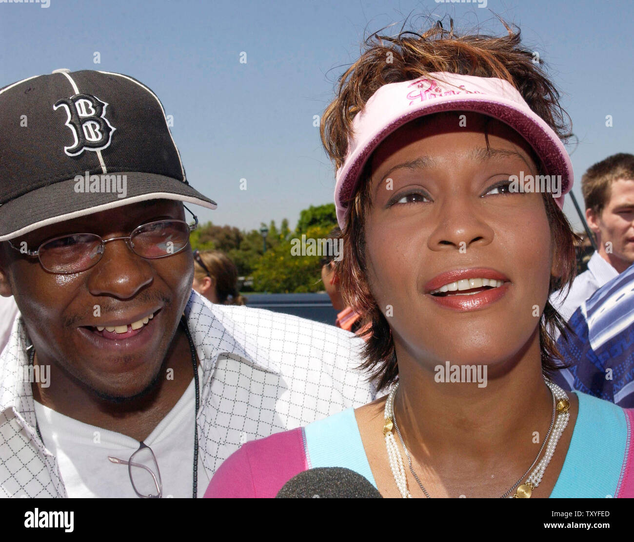 Whitney Houston (R) arrives with her husband, Bobby Brown at Disneyland in Anaheim, California on August 7, 2004. Houston has filed for divorce from Brown, her spokeswoman said on Wednesday, September 13, 2006 following 14 tumultuous years of marriage and tabloid headlines. (UPI Photo/Jim Ruymen/file photo) Stock Photo