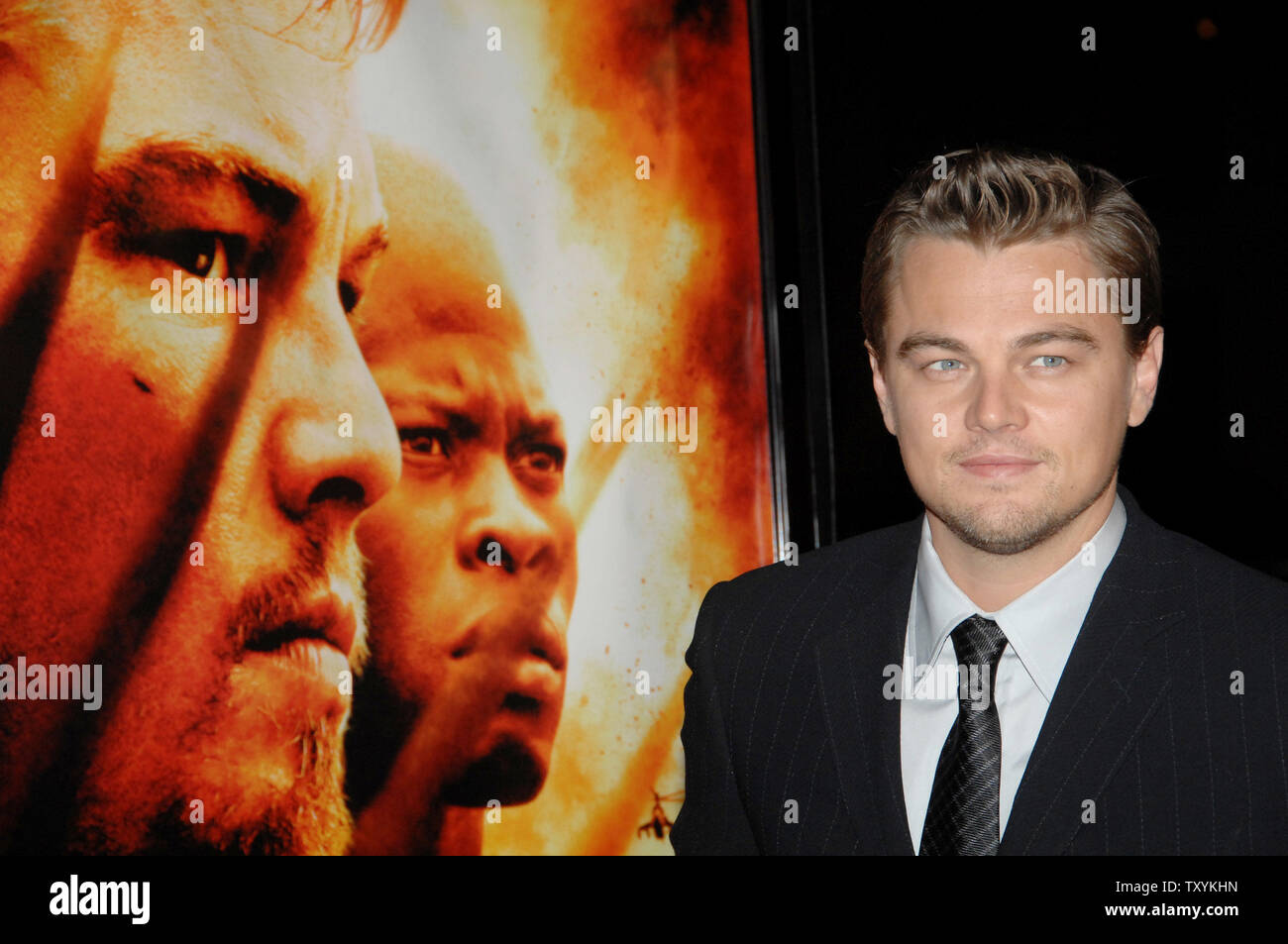 Actor Leonardo DiCaprio, star of the new motion picture drama 'Blood Diamond', stands next to his photograph on the film's poster as he arrives for the premiere of the film at Grauman's Chinese Theatre in the Hollywood section of Los Angeles on December 6, 2006. The film, set in Sierra Leone is about a quest to recover a rare diamond. (UPI Photo/Jim Ruymen) Stock Photo