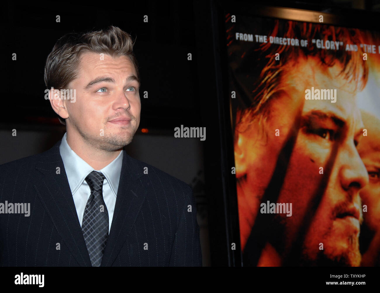 Actor Leonardo DiCaprio, star of the new motion picture drama 'Blood Diamond', stands next to his photograph on the film's poster as he arrives for the premiere of the film at Grauman's Chinese Theatre in the Hollywood section of Los Angeles on December 6, 2006. The film, set in Sierra Leone is about a quest to recover a rare diamond. (UPI Photo/Jim Ruymen) Stock Photo