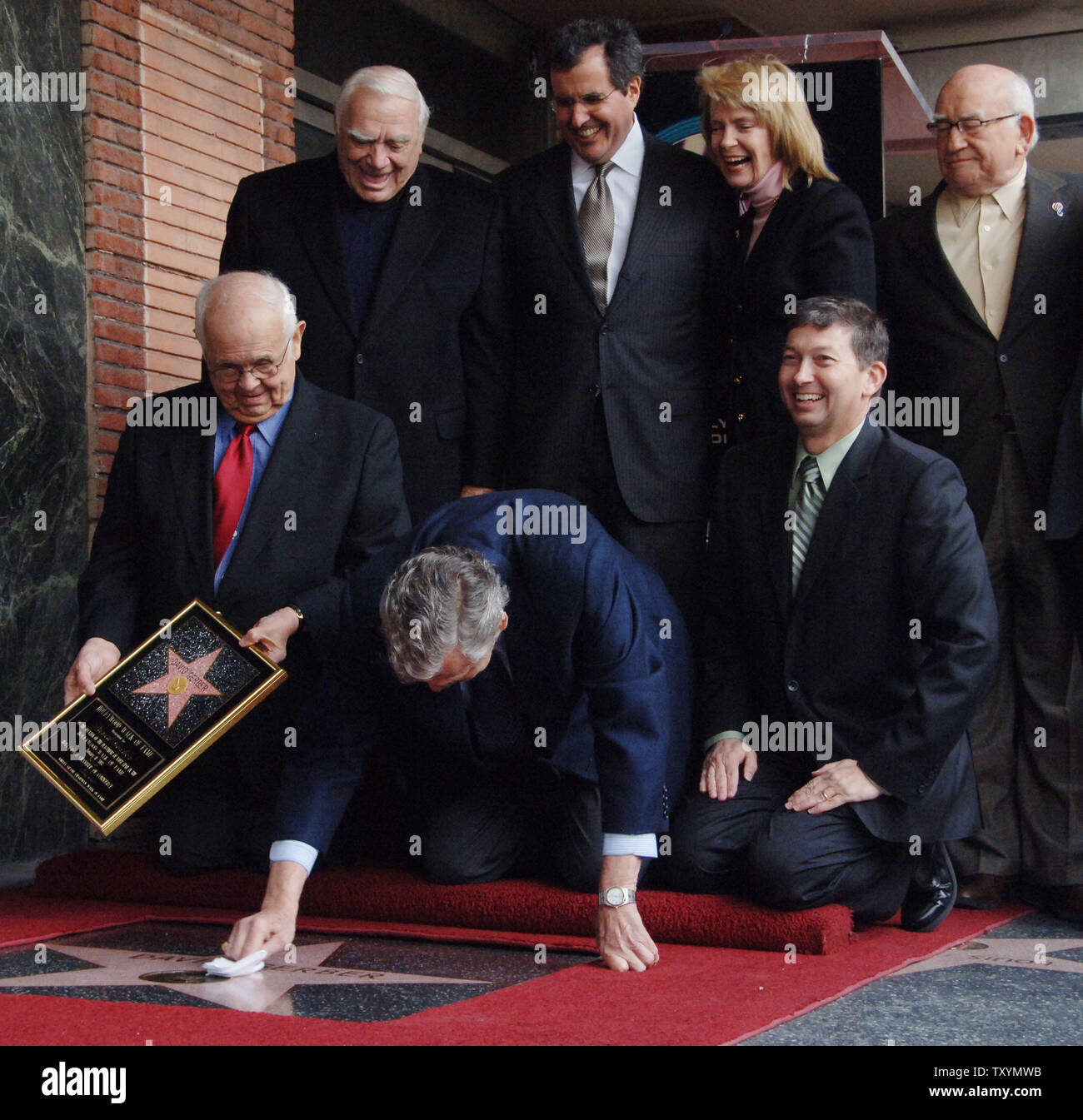 David Gerber (C), an Emmy and Peabody Award winner, facetiously cleans his star after it was unveiled during a ceremony honoring the television industry veteran with the 2,326th star on the Hollywood Walk of Fame in Los Angeles on January 11, 2007. Looking on are Ernest Borgnine, Peter Chernin, Laraine Stephens and Ed Asner (L-R, rear). Gerber's accomplishments include such classic television projects as 'Batman', 'Room 222', 'thirtysomething', 'Police Story', 'Police Woman', the 'George Washington' miniseries, 'The Lindbergh Kidnapping Case', 'In the Heat of the Night' and 'The Lost Battalion Stock Photo