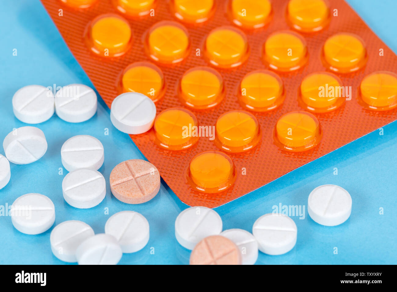 Pills and a blister pack on a blue background Stock Photo