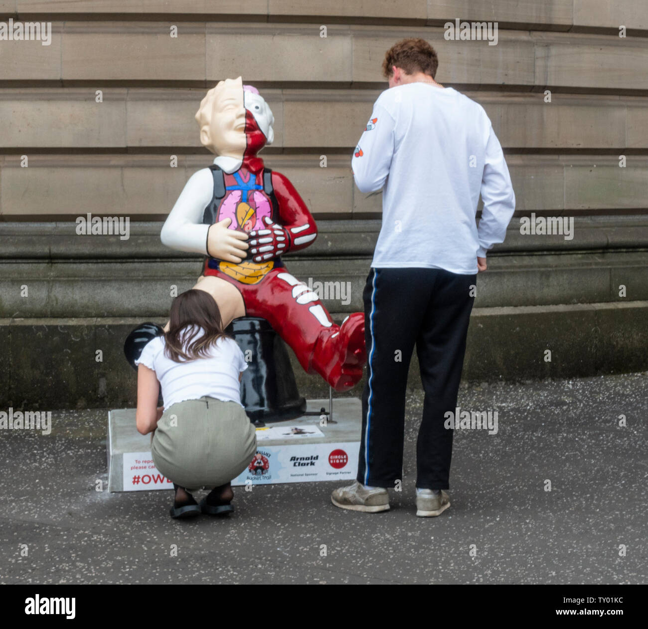A young couple examine Anatomical Boy by Simon Messer, part of the Oor