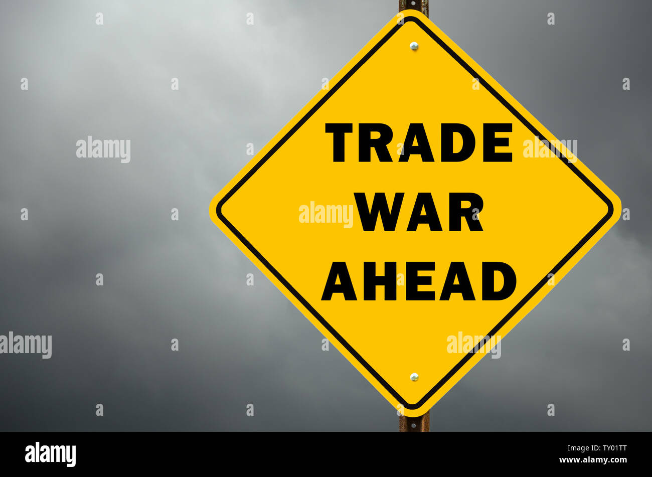 Trade war ahead conceptual ywllow warning road sign against stormy sky Stock Photo