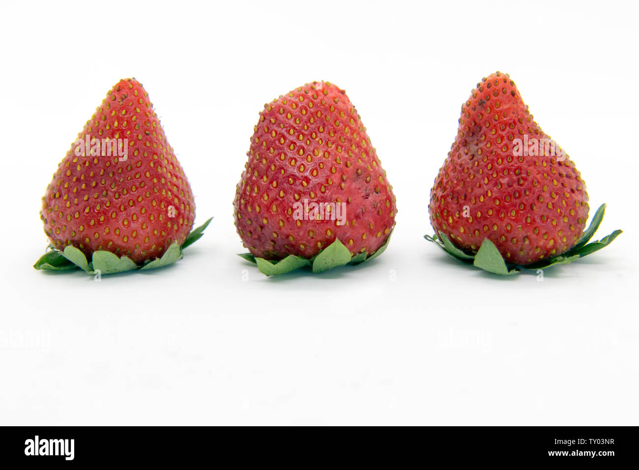 Three strawberries close up isolated on white Stock Photo - Alamy