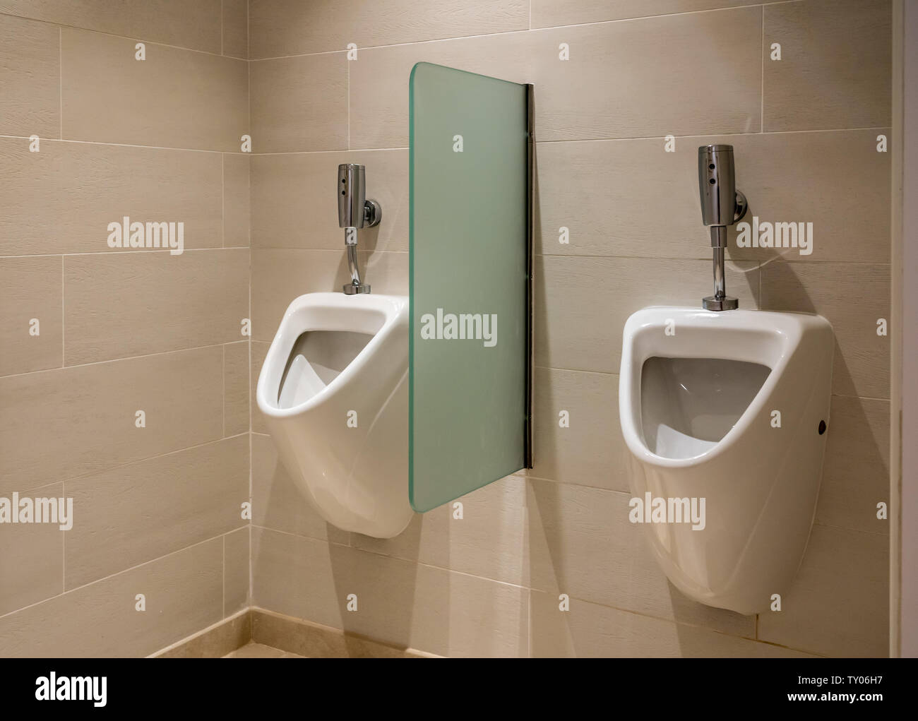 Two automatic flush urinals in mens restroom Stock Photo