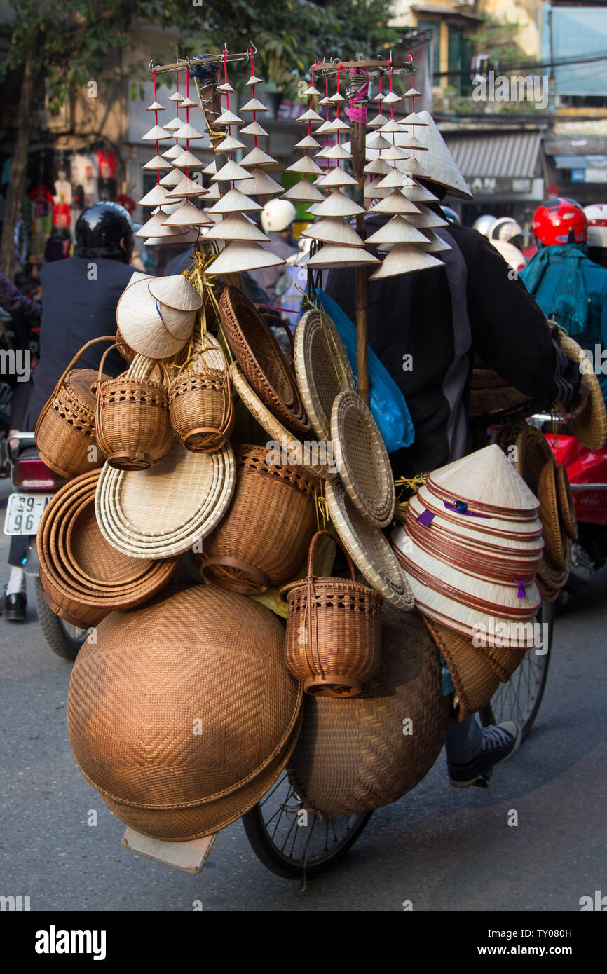 Hanoi: Vietnam person selling hats on a bicycle. Stock Photo