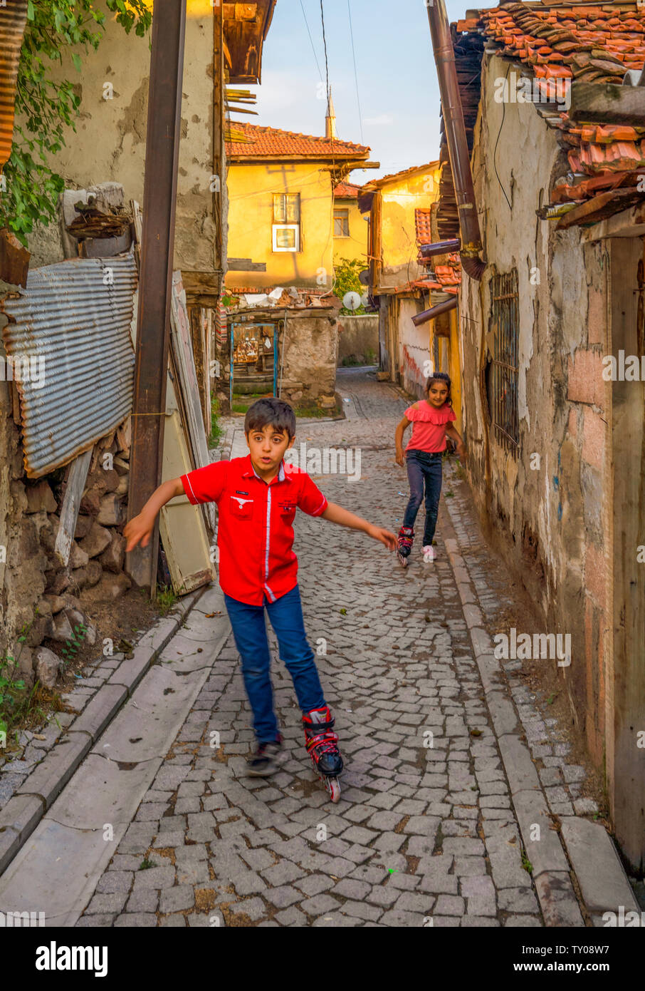 Ankara/Turkey-June 16 2019: Children playing with roller skate on the street near Ankara Castle. Concept of sharing. Children use only one roller skat Stock Photo