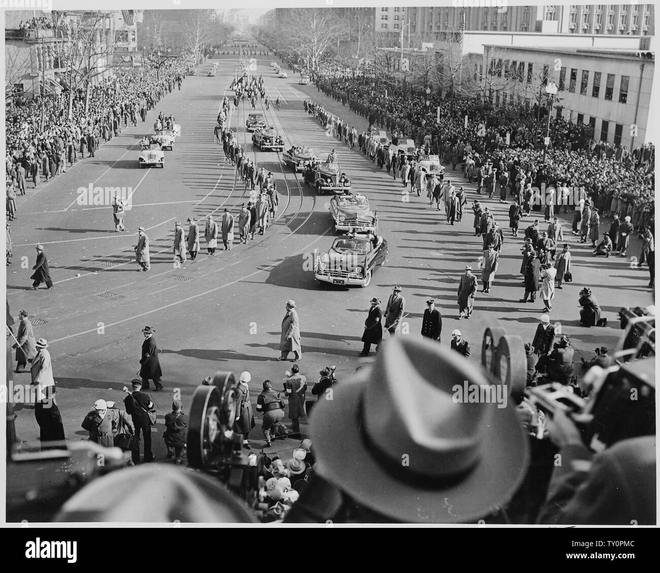 Distance view of procession of limousines as President Truman rides to the reviewing stand for
