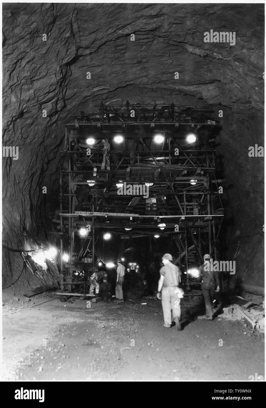 Drilling jumbo used in upper 36 feet of 41-foot diameter upper penstock header. This view shows the drilling face.; Scope and content:  Photograph from Volume Two of a series of photo albums documenting the construction of Hoover Dam, Boulder City, Nevada. Stock Photo