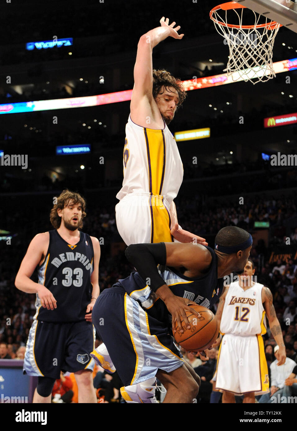 Los Angeles Lakers center Pau Gasol (16) of Spain, fouls Hakim Warrick as  his brother and Memphis Grizzlies center Marc Gasol (33) looks on during  the second half of an NBA basketball