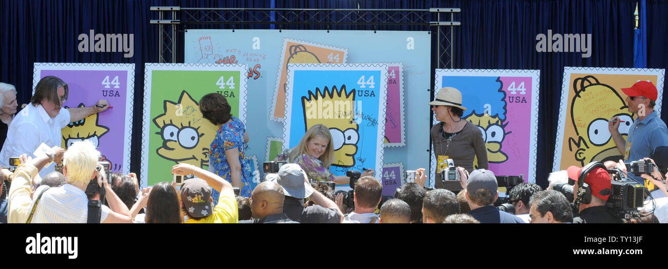 Creator and Executive Producer Matt Groening, Yeardley Smith, the voice of Lisa Simpson, Nancy Cartwright, the voice of Bart Simpson, Julie Kavner, the voice of Marge Simpson and Dan Castellaneta, the voice of Homer Simpson (L) sign posters at the unveiling of the new 'The Simpsons' U.S. postage stamps in Los Angeles May 7, 2009. (UPI Photo/Jim Ruymen) Stock Photo