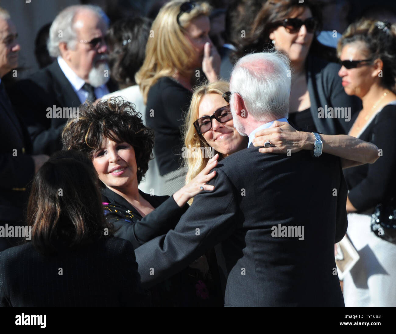 Alana Stewart (C) best friend of late actress Farrah Fawcett hugs Leonard Goldberg, producer of Fawcett's TV series 'Charlie's Angels' as songwriter Carole Bayer Sager (L) looks on following Fawcett's funeral at the Cathedral of Our Lady of Angels in Los Angeles June 30, 2009. (UPI Photo/Jim Ruymen) Stock Photo
