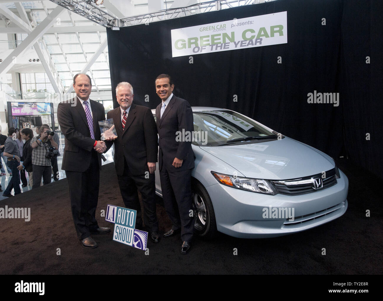 Michael Accavitti (L-R), vice president of marketing for American Honda, Green Car Journal editor and publisher Ron Cogan and Los Angeles Mayor Antonio Villaraigosa pose with the Honda Civic natural gas vehicle which was named Green Car of theYear for 2012 at the Los Angeles Auto Show held at the convention center in Los Angeles on November 17, 2011.      UPI/Phil McCarten Stock Photo