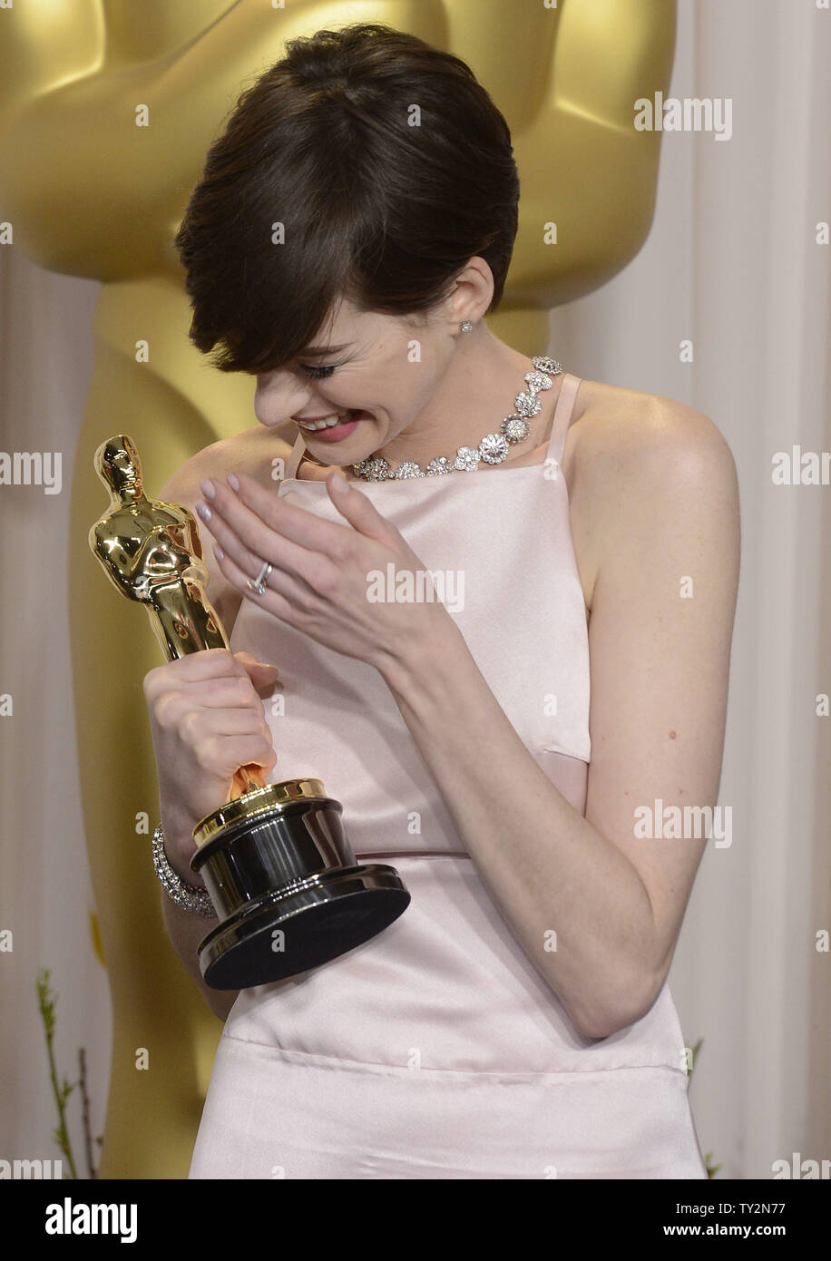 Anne Hathaway becomes emotional as she poses with her Oscar for Performance by an Actress in a Supporting Role for "Les Miserables" backstage at the 85th Academy Awards at the Hollywood and Highlands Center in the Hollywood section of Los Angeles on February 24, 2013. UPI/Phil McCarten Stock Photo