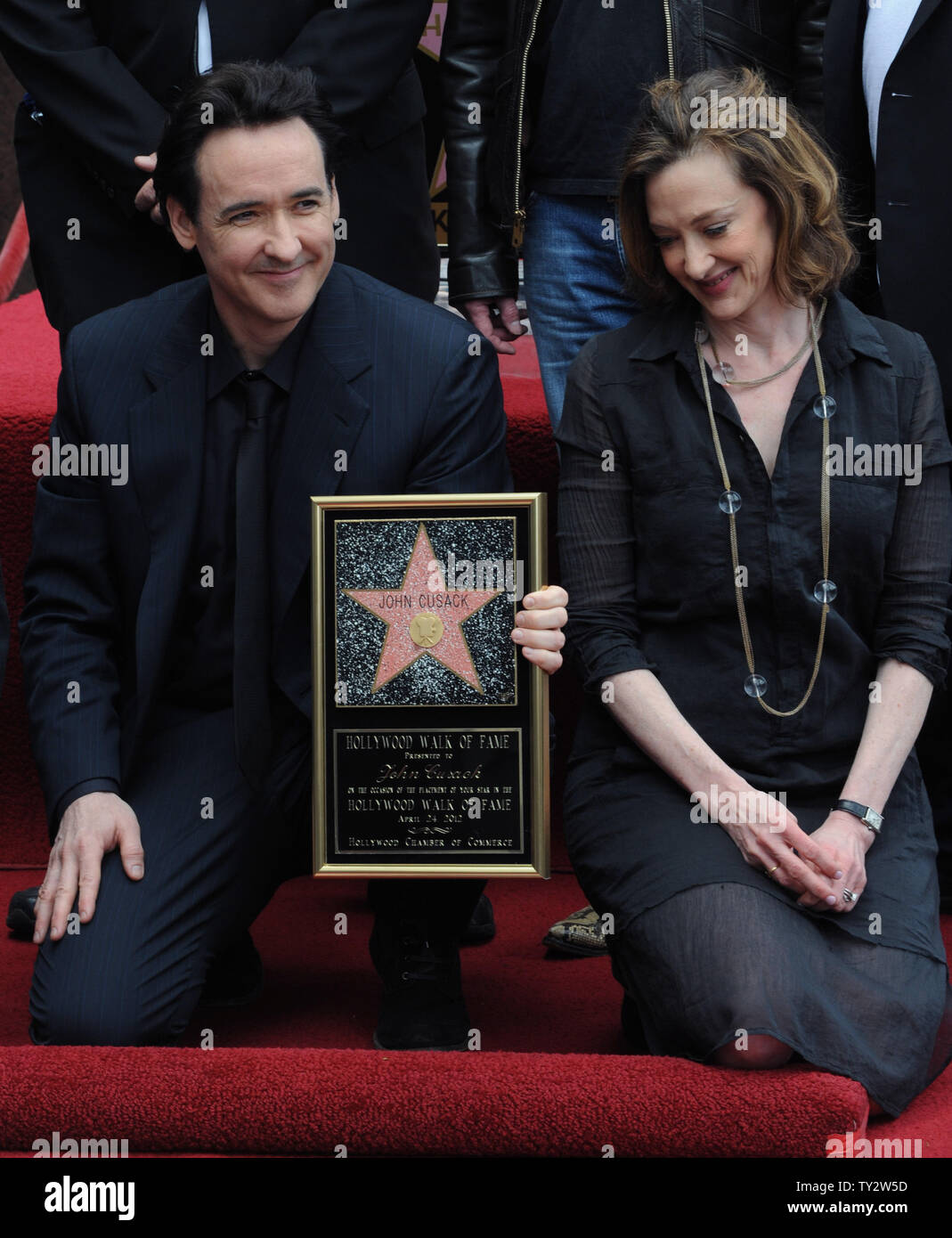 Actor John Cusack holds a replica plaque during an unveiling ceremony