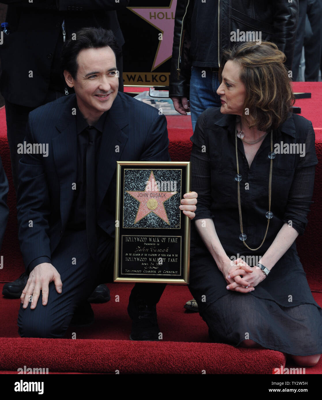Actor John Cusack holds a replica plaque during an unveiling ceremony