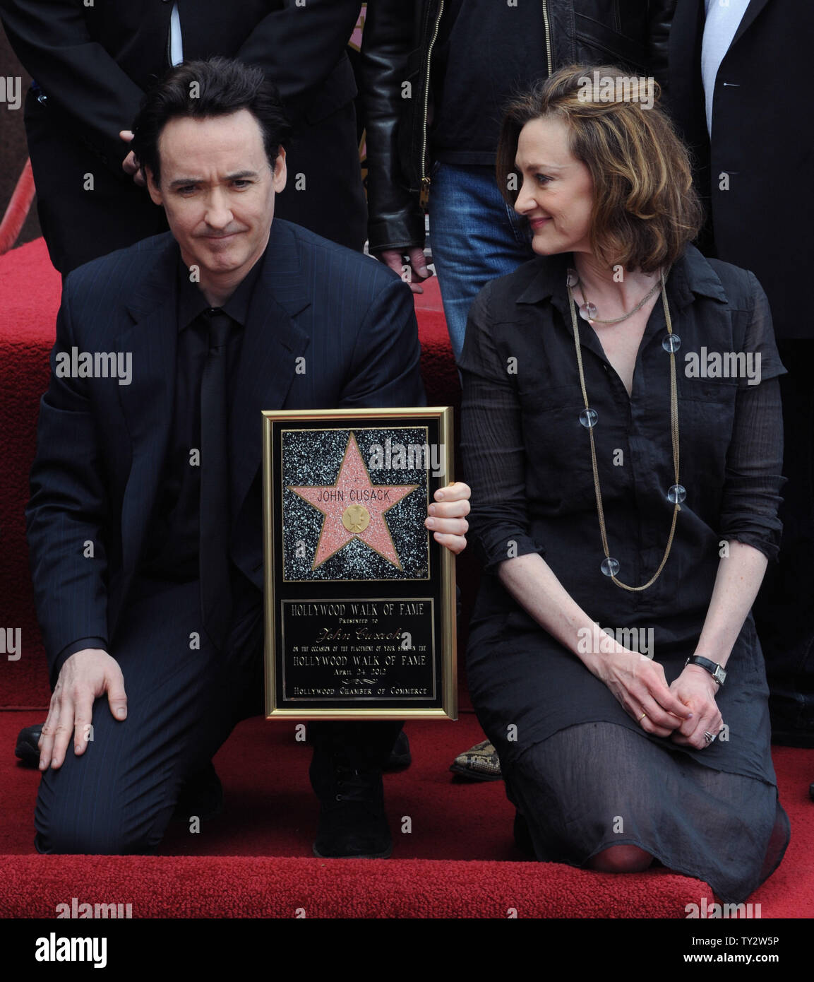 Actor John Cusack holds a replica plaque during an unveiling ceremony
