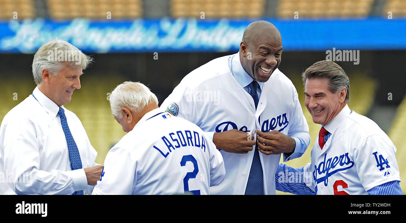 Tommy Lasorda presents Mark Walter (L) with a Dodger jersey as Steve Garvey  presents Irvin Magic Johnson with one as the new owners of the Los  Angeles Dodgers, known as the Guggenheim
