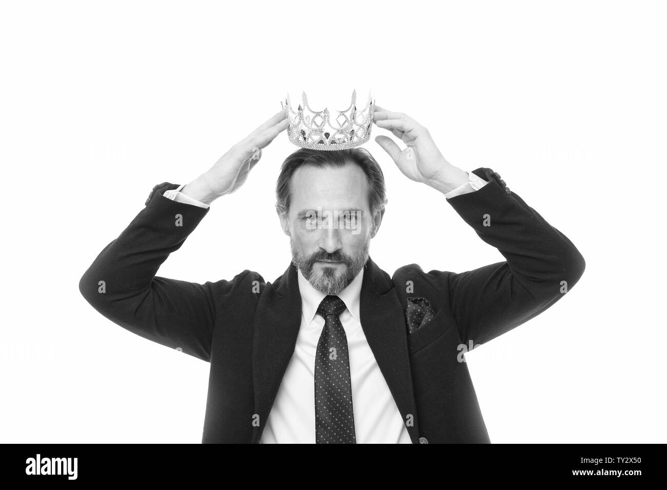 He is noble every inch of him. Mature businessman trying on crown. Fit for a king. Business king. Senior man representing power. Success in business. King of style. Achieving victory and success. Stock Photo