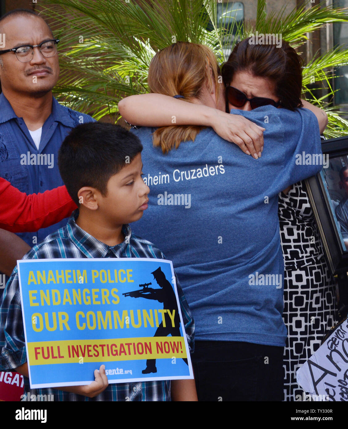 Corie Cline (C) and Barbara Padilla hug during a news conference outside state Attorney General Kamala Harris' office in Los Angeles, California on July 30, 2012, before presenting a petition urging her to investigate Anaheim police over recent officer-involved shootings. Cline's brother Joe Whitehouse and Padilla's son Marcel Ceja were shot and killed by police in separate incidents.  UPI/Jim Ruymen Stock Photo