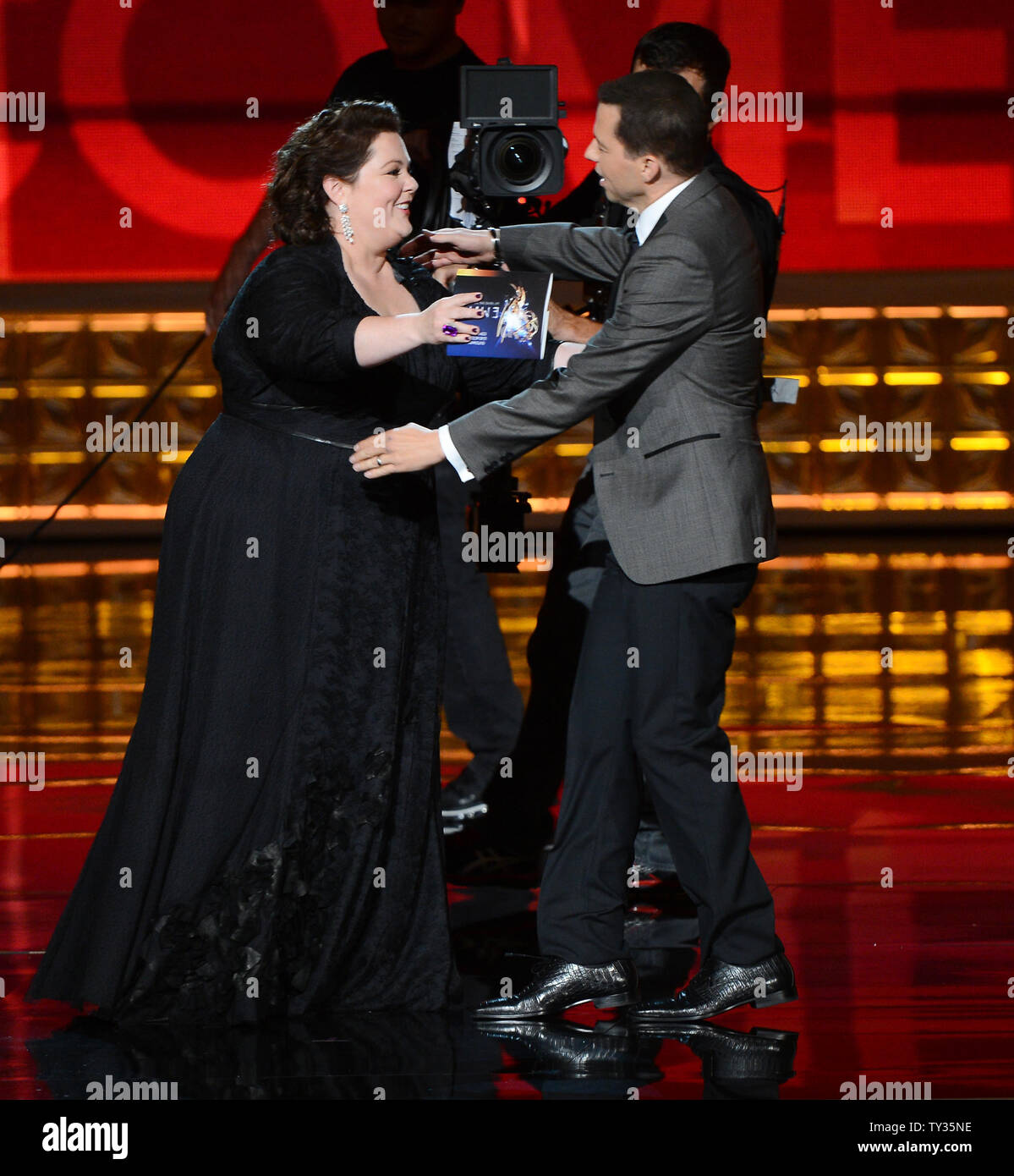 Actress Melissa McCarthy presents the Emmy Award to actor Jon Cryer onstage  at the 64th Primetime