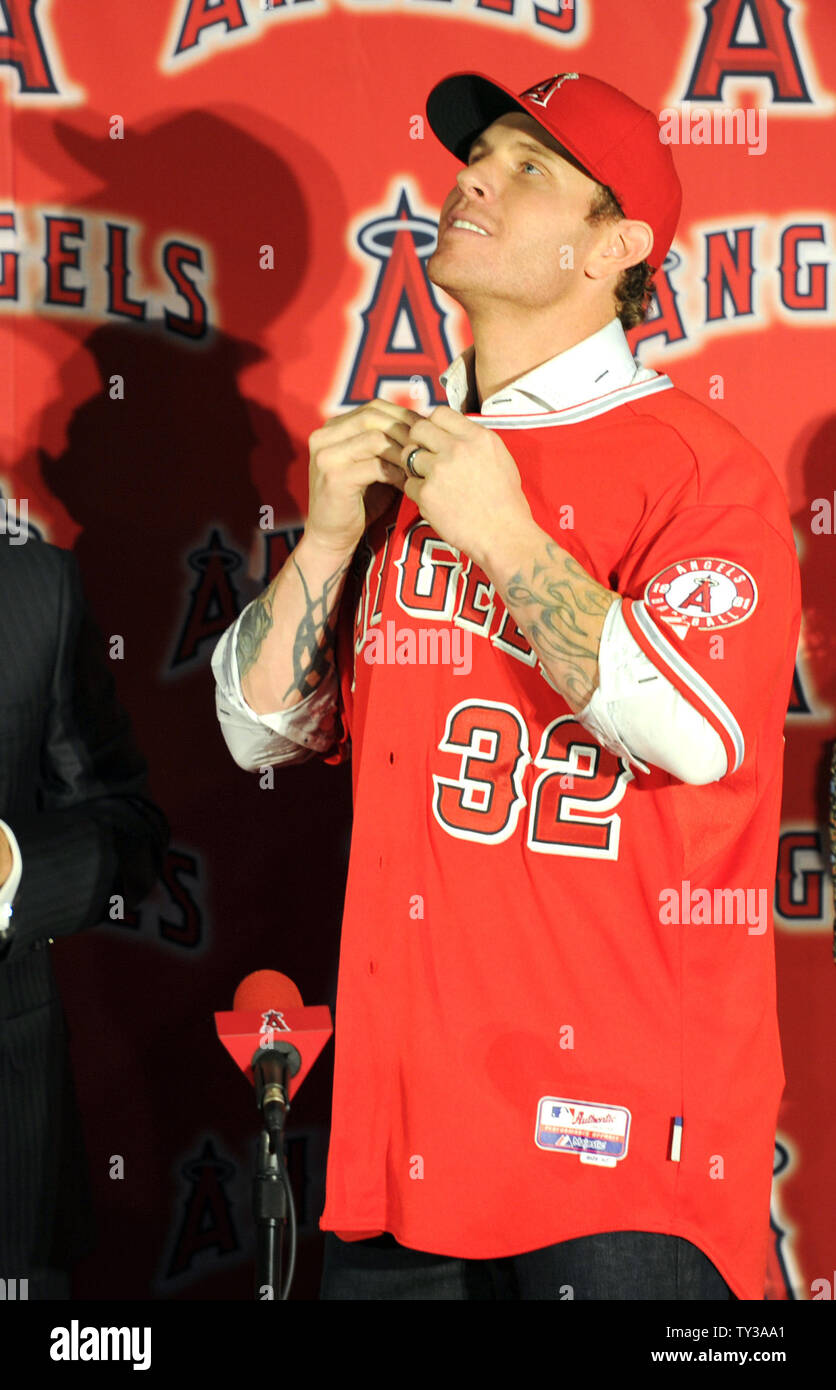 The Los Angeles Angels owner, Arte Moreno gives outfielder, Josh Hamilton  his jersey and hat in a press conference at ESPN Zone at Downtown Disney in  Anaheim, California on December 15, 2012.