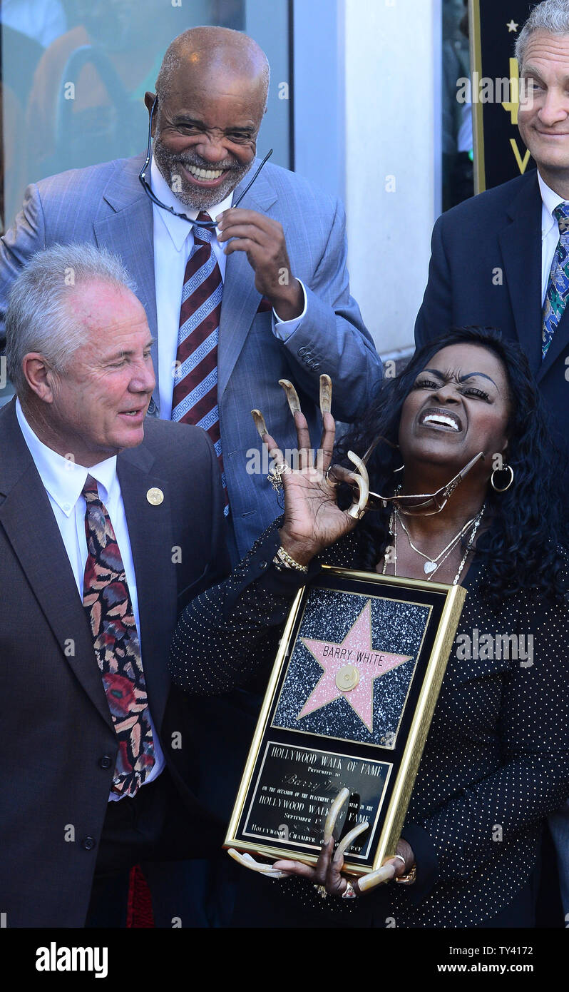 Glodean White, the wife of singer Barry White holds a replica plaque as she  shares a laugh with Motown founder Berry Gordy, (2nd-L), during an  unveiling ceremony honoring White posthumously with the