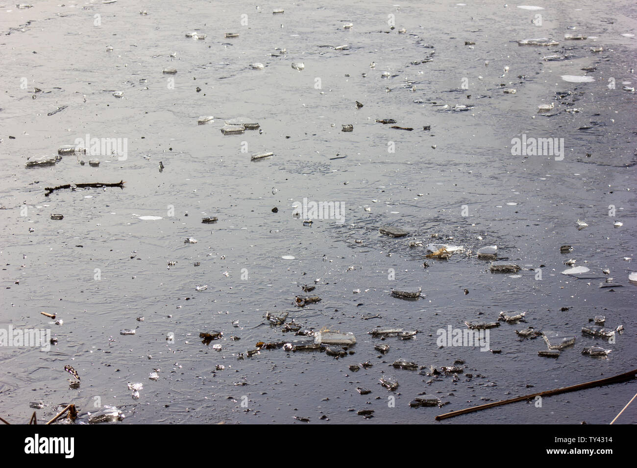 Beautiful frozen lake, covered with shattering ice.Ice cubes and broken ice on top.Bubbles under